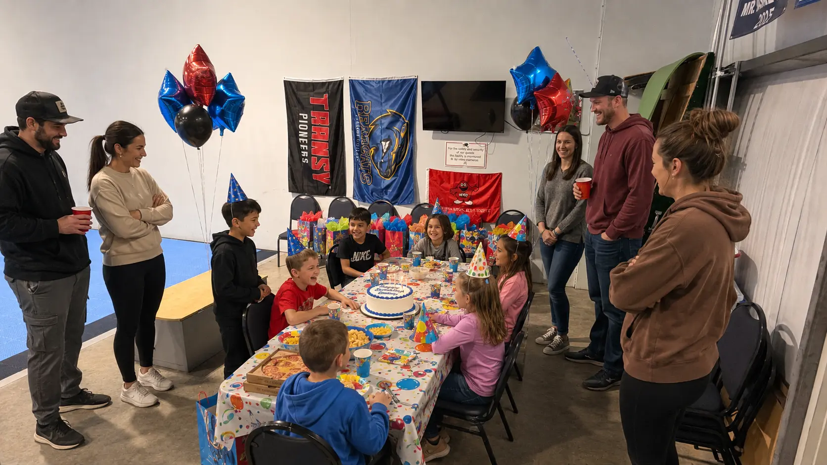 Kids celebrating a birthday party at Elite Labs with cake and balloons